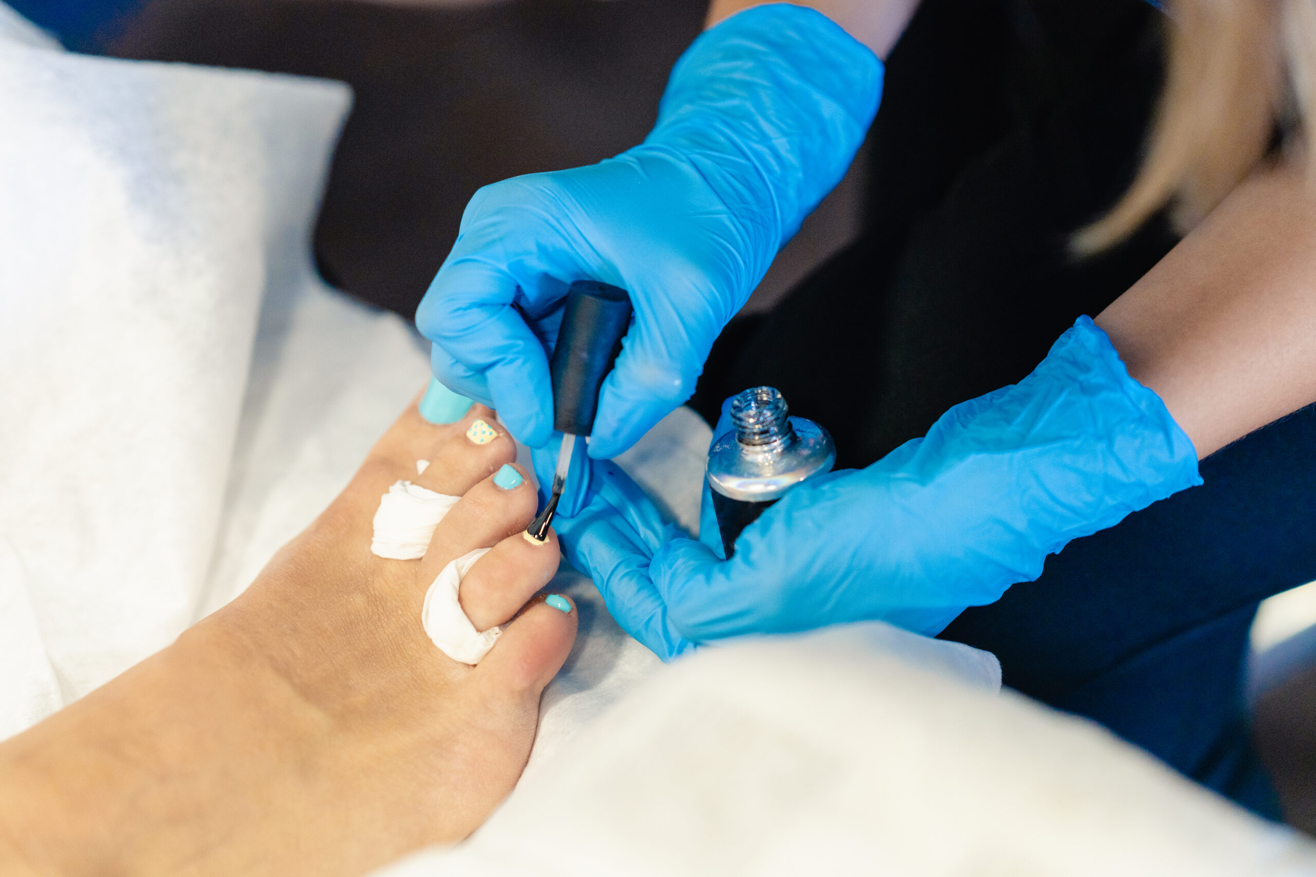 Beautician giving a pedicure painting her client's nails in a beauty centre.